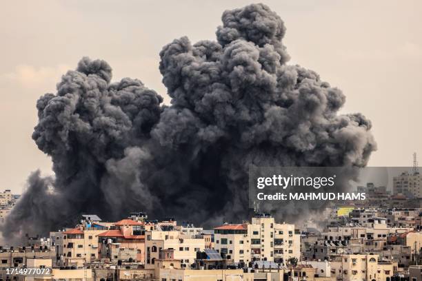 Plume of smoke rises in the sky of Gaza City during an Israeli airstrike on October 9, 2023. Israel relentlessly pounded the Gaza Strip overnight and...