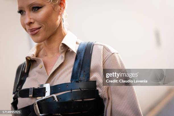 Guest wears a beige shirt and black leather harness, outside Louis Vuitton, during the Womenswear Spring/Summer 2024 as part of Paris Fashion Week on...