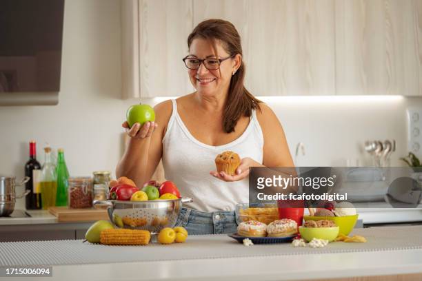 la donna sceglie cibo sano piuttosto che cibo spazzatura - fat people eating donuts foto e immagini stock