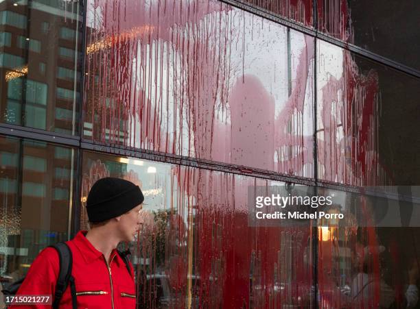 Protestor after throwing red paint over the windows of the Rotterdam Harbour office in protest against the 'crucial role the harbour plays in the...