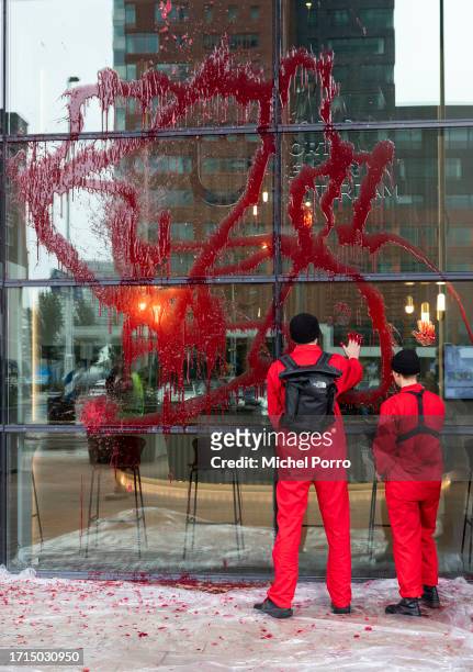 Protestors have thrown red paint over the windows of the Rotterdam Harbour office in protest against the 'crucial role the harbour plays in the...