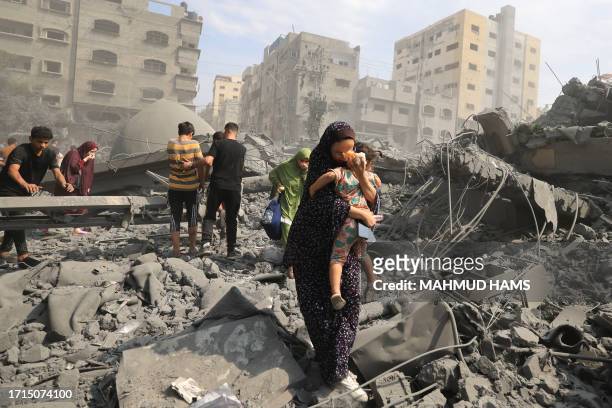 Palestinians evacuate the area following an Israeli airstrike on the Sousi mosque in Gaza City on October 9, 2023. Israel continued to battle Hamas...