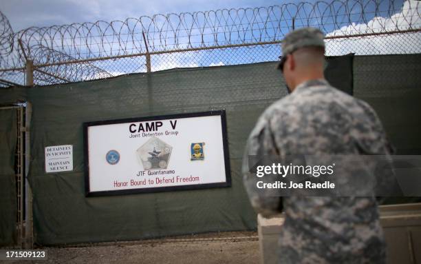 Soldier stands near the wall around camp V where prisoners are housed in a single cell facility which is part of the U.S. Military prison for 'enemy...