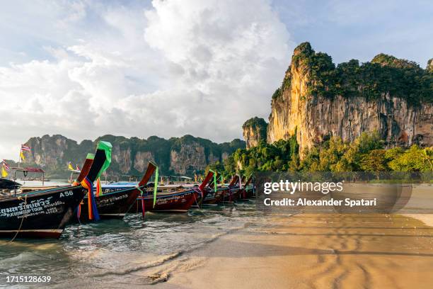 long-tail boats on railay beach, krabi, thailand - long tail boat stock-fotos und bilder