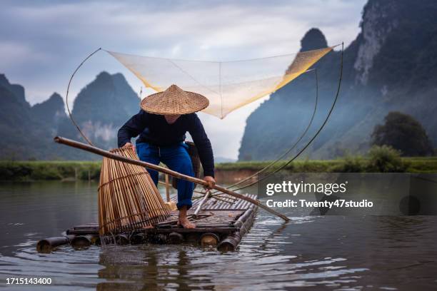 a fisherman on raft fishing in the river in north vietnam - cao bang stock pictures, royalty-free photos & images