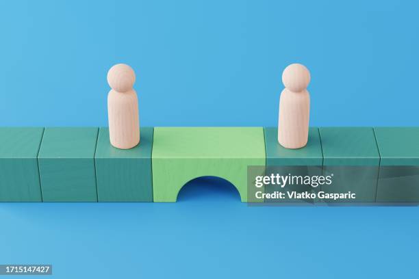 bridge between two wooden figurines - green chess piece stock pictures, royalty-free photos & images