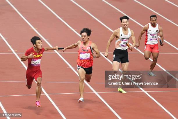 Chen Jiapeng of Team China leads Uno Shoto of Team Japan as they cross the finish line in the Athletics - Men's 4 x 100m Relay on day ten of the 19th...