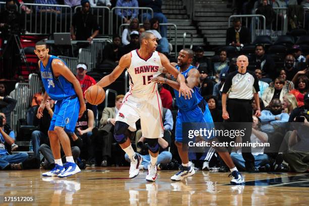 Al Horford of the Atlanta Hawks controls the ball against Mike James of the Dallas Mavericks on March 18, 2013 at Philips Arena in Atlanta, Georgia....