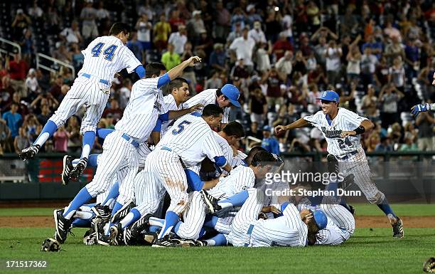 Te UCLA Bruins jump into a pile to celebrate after getting the final out against the Mississippi State Bulldogs during game two of the College World...