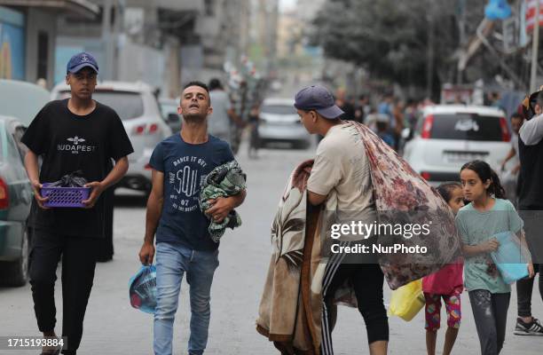 Palestinians evacuate their homes after Israeli strikes on Gaza City on October 9, 2023. The Israeli army said it hit more than 500 targets in the...