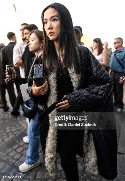 Yoyo Cao is seen wearing a black and faux fur Louis Vuitton coat with a black Louis Vuitton bag outside the Louis Vuitton show during the Womenswear...