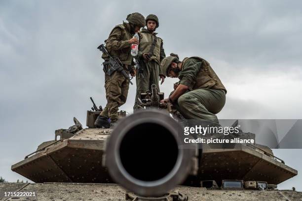 October 2023, Israel, ---`: Israeli soldier work on a tank at the Israel-Gaza border. Fighting between Israeli soldiers and Islamist Hamas militants...