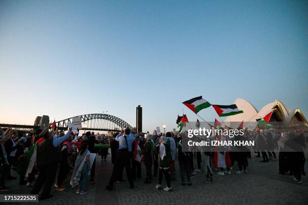 Protesters show their support for Palestinians during a rally in front of the Opera House in Sydney on October 9, 2023. Israel relentlessly pounded...