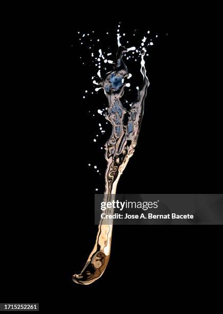drops of gold-colored liquid fall on a black background. - bouncing stock pictures, royalty-free photos & images