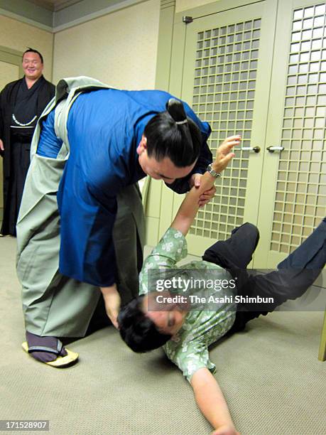 Mongolian Yokozuna, sumo grand champion Harumafuji , whose real name is Davaanyamyn Byambadorj throws Nagoya city mayor Takashi Kawamura during their...