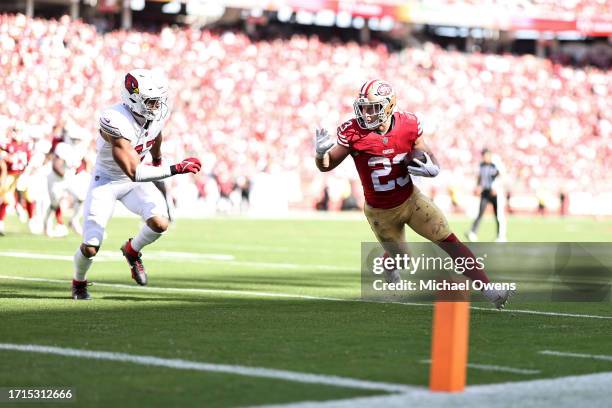 Christian McCaffrey of the San Francisco 49ers runs with the ball against Ezekiel Turner of the Arizona Cardinals during an NFL football game between...