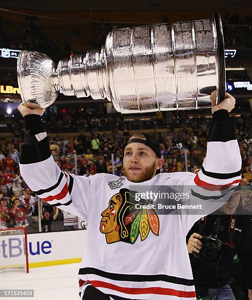 Patrick Kane of the Chicago Blackhawks carries the Stanley Cup following a 3-2 victory over the Boston Bruins in Game Six of the 2013 NHL Stanley Cup...
