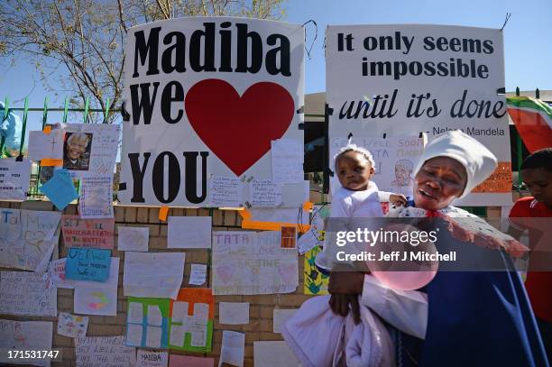 People gather to leave messages of support for former South African President Nelson Mandela outside the Mediclinic Heart Hospital June 26, 2013 in...