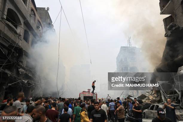 Palestinians search for survivors after an Israeli airstrike on buildings in the refugee camp of Jabalia in the Gaza Strip on October 9, 2023. Israel...