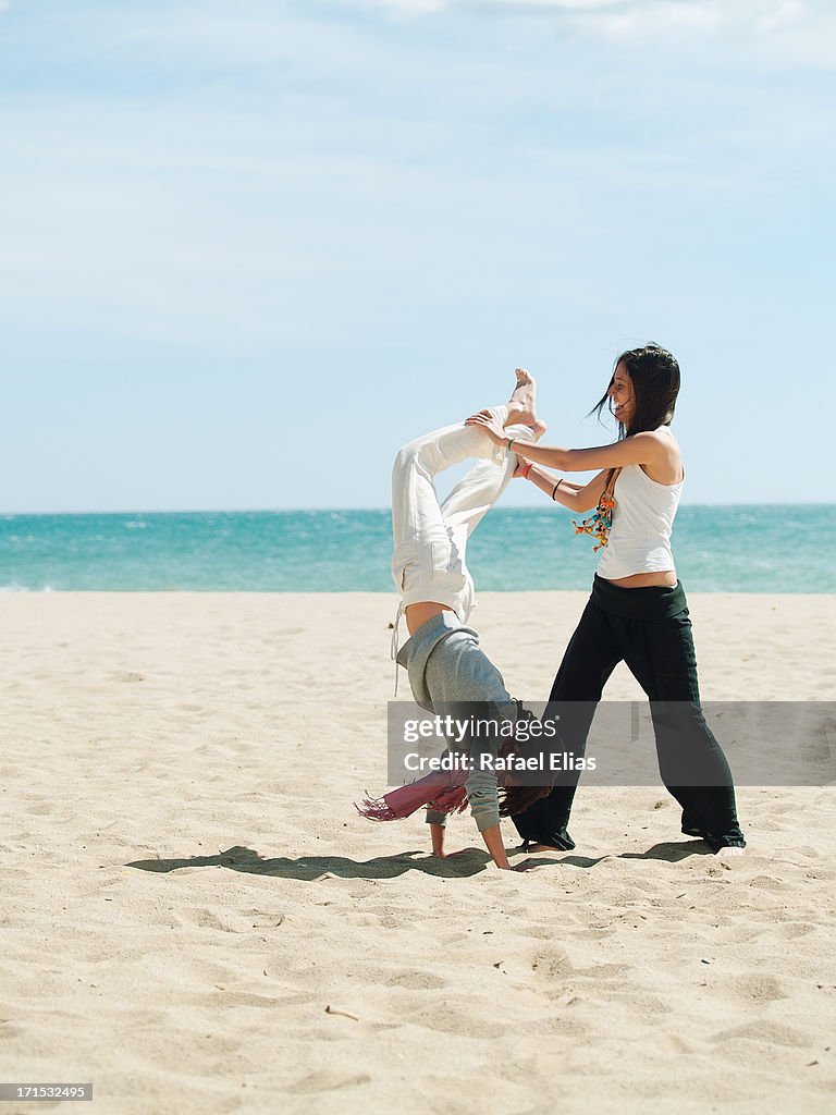 Two gymnastic young women on the beach