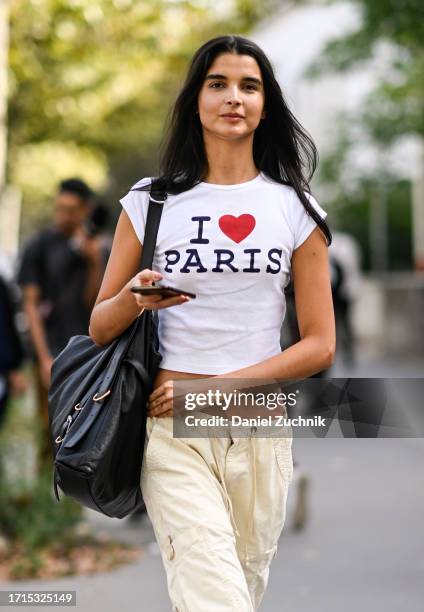 Model is seen wearing a Paris t-shirt, yellow pants and black bag outside the Zimmermann show during the Womenswear Spring/Summer 2024 as part of...