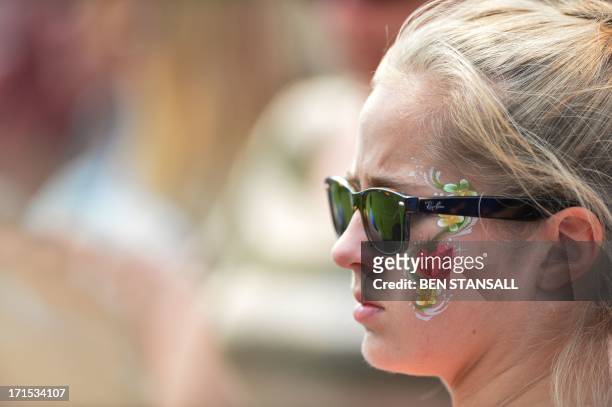Spectator wears face-painting of a strawberry on her cheek on day three of the 2013 Wimbledon Championships tennis tournament at the All England Club...