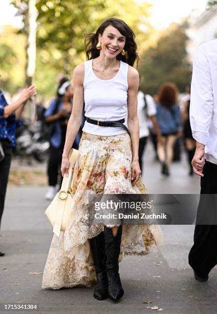 Mary Leest is seen wearing a white top, black belt, Zimmermann floral lace skirt, black boots and cream bag with gold earrings outside the Zimmermann...