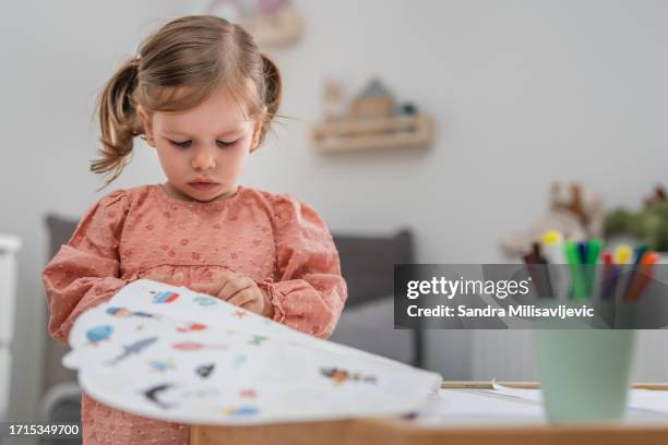 one toddler girl playing with markers and stickers, creativity development concept - sticker stock pictures, royalty-free photos & images