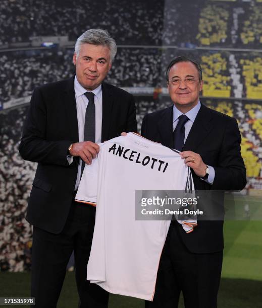 Carlo Ancelotti holds up a Real Madrid shirt as he stands alongside club president Florentino Perez while being presented as Real Madrid's new head...