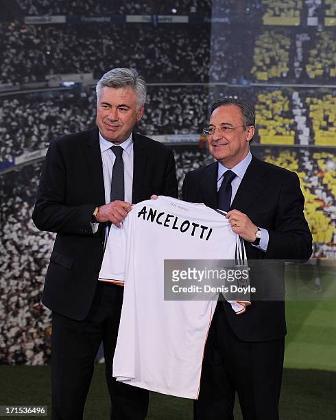 Carlo Ancelotti holds up a Real Madrid shirt as he stands alongside club president Florentino Perez while being presented as the new head coach of...