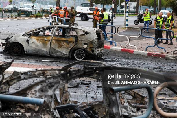 Israeli emergency responders cordon off the site of a rocket attack in the southern Israeli city of Ashdod on October 9, 2023. Stunned by the...