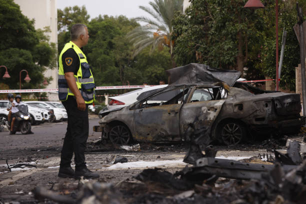 An Israeli emergency responder near the cordoned off site of destroyed cars following a missile strike by Palestinian militants in Ashdod, Israel, on...