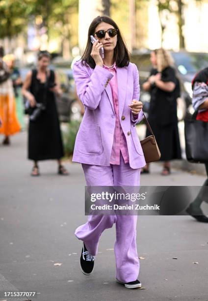 Guest is seen wearing a purple suit with black sunglasses outside the Zimmermann show during the Womenswear Spring/Summer 2024 as part of Paris...