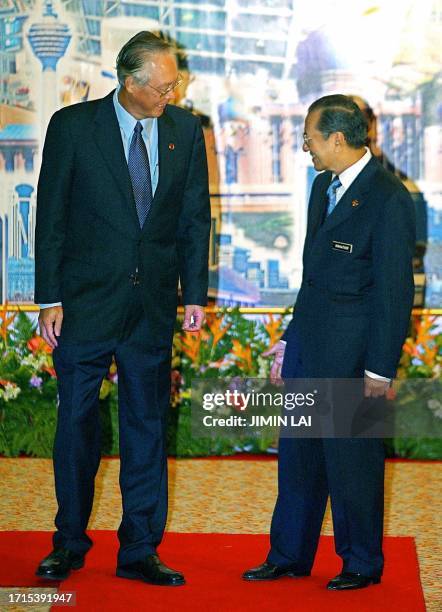 Singaporean Prime Minister Goh Chok Tong chats with Malaysian Prime Minister Mahathir Mohamad upon arriving at the 13th Non-Aligned Movement Summit...