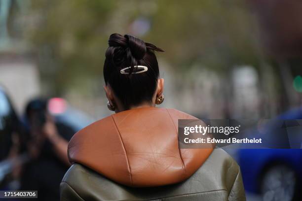 Guest wears a winter jacket with leather hood, outside Miu Miu, during the Womenswear Spring/Summer 2024 as part of Paris Fashion Week on October 03,...