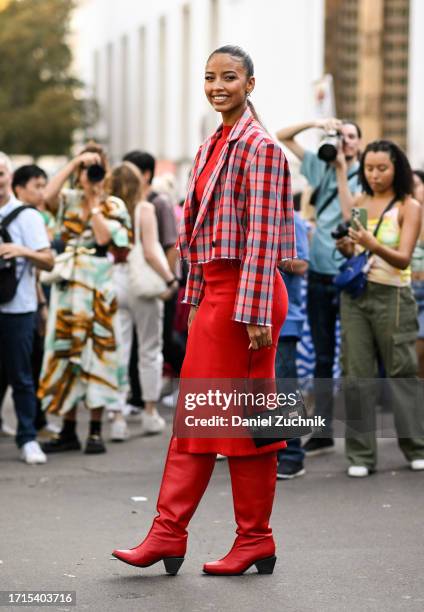 Guest is seen wearing a red and white plaid jacket, red dress, red boots and black and gold bag outside the Zimmermann show during the Womenswear...