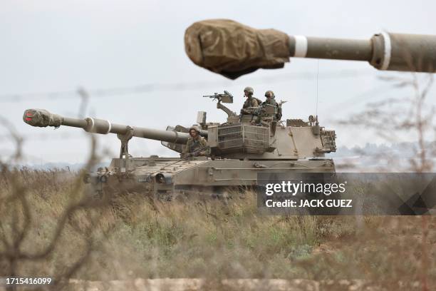 Israeli army soldiers are positioned with their armoured vehicles near the border with the Gaza Strip in southern Israel on October 9, 2023. Israel...