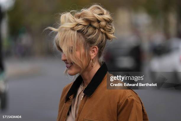 Guest wears a brown jacket, earrings, outside Miu Miu, during the Womenswear Spring/Summer 2024 as part of Paris Fashion Week on October 03, 2023 in...