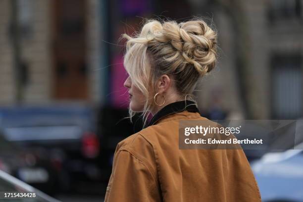 Guest wears a brown jacket, earrings, outside Miu Miu, during the Womenswear Spring/Summer 2024 as part of Paris Fashion Week on October 03, 2023 in...