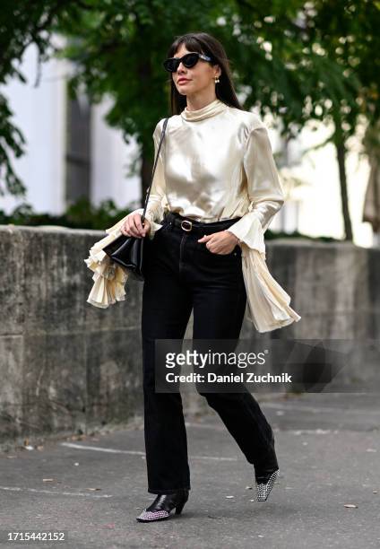 Kat Collings is seen wearing a cream Zimmermann metallic top, black pants and black bag with black sunglasses outside the Zimmermann show during the...