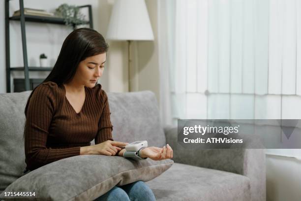 blutdruckmanagement: die gesundheitspriorität einer überarbeiteten frau - niedrig stock-fotos und bilder