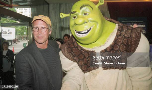 American actor Chevy Chase poses with a costumed 'Shrek' performer at a screening of 'Shrek,' New York, New York, May 15, 2001.