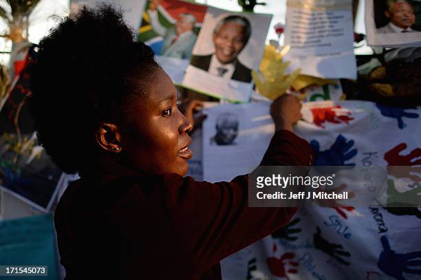 People gather to leave messages of support for former South African President Nelson Mandela outside the Mediclinic Heart Hospital June 26, 2013 in...