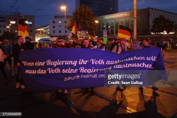 Supporters of the far-right "Zukunft Heimat" movement, including some holding a banner that reads: "When a government wants to exchange its people,...