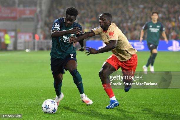 Bukayo Saka of Arsenal is put under pressure by Deiver Machado of RC Lens during the UEFA Champions League match between RC Lens and Arsenal FC at...