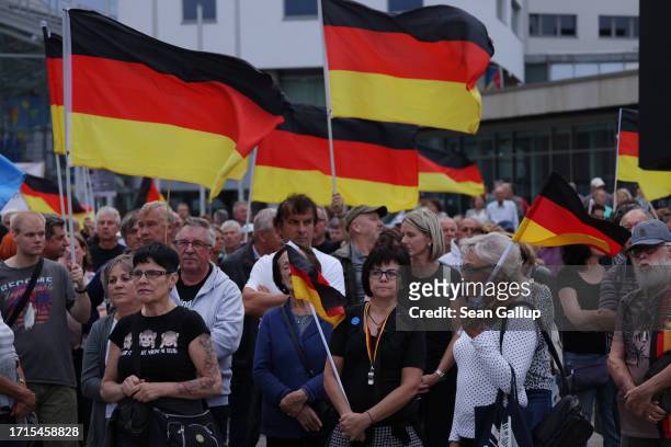 Supporters of the far-right "Zukunft Heimat" movement listen to speeches and hold up German flags at a gathering on German Unity Day on October 03,...