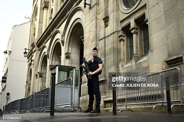 French riot policeman stands guard outside the Paris Synagogue, two days after security measures have been reinforced near Jewish temples and...