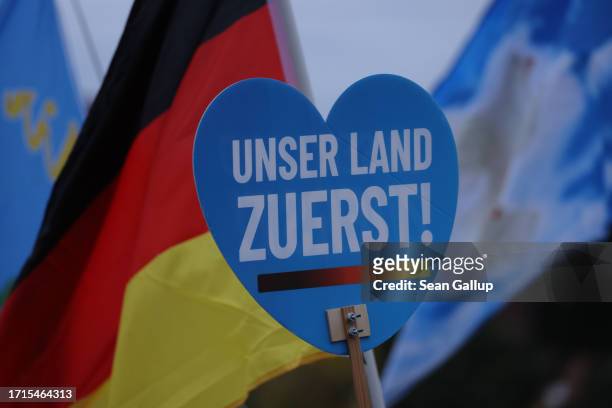 Supporters of the far-right "Zukunft Heimat" movement, including one holding a sign that reads: "Our country first!", gather to hear speeches on...