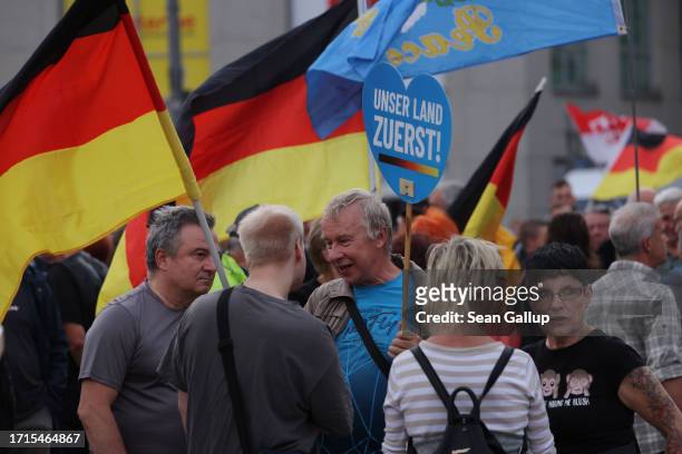 Supporters of the far-right "Zukunft Heimat" movement hold up German flags at a gathering on German Unity Day on October 03, 2023 in Cottbus,...