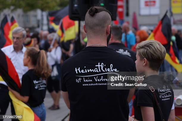 Supporters of the far-right "Zukunft Heimat" movement, including some with black t-shirts that read: "Love of homeland is not a crime," gather with...